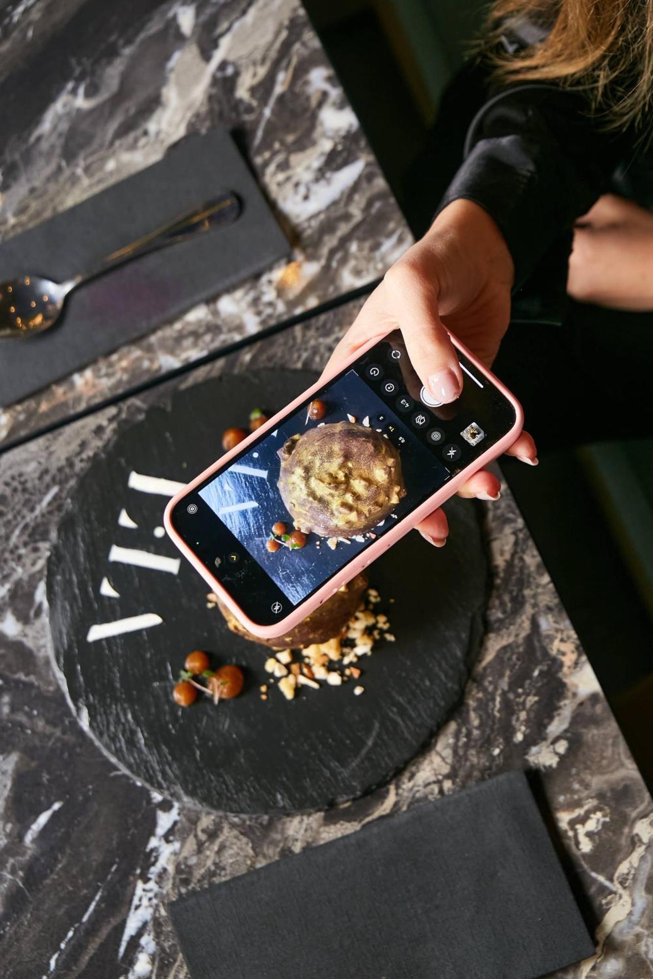Pullman Santiago El Bosque Hotel Kültér fotó A smartphone being used to take a photograph of a food item